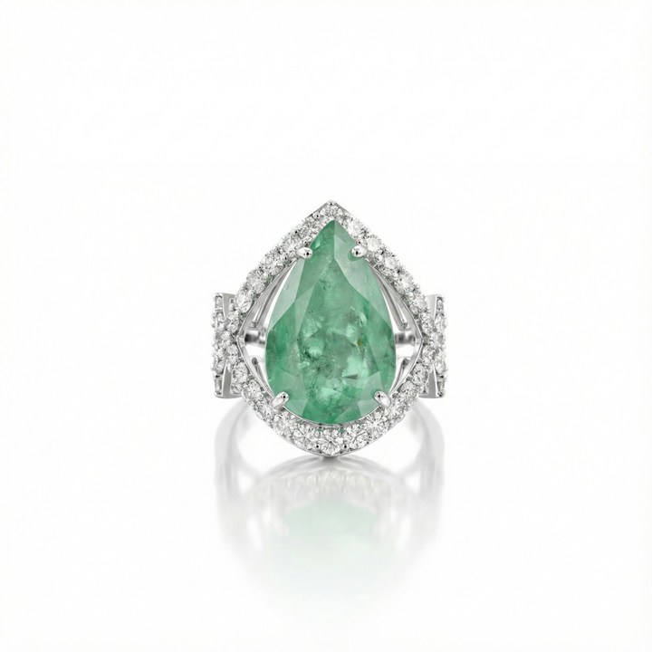 ANEL COM LATERAL TRABALHADA ESMERALDA COLOMBIANA GOTA 10,67CT 60 BRILHANTES 2,36CT H VS2 11,00G OURO BRANCO 18K - COLEÇAO COLOMBIA EMERALD